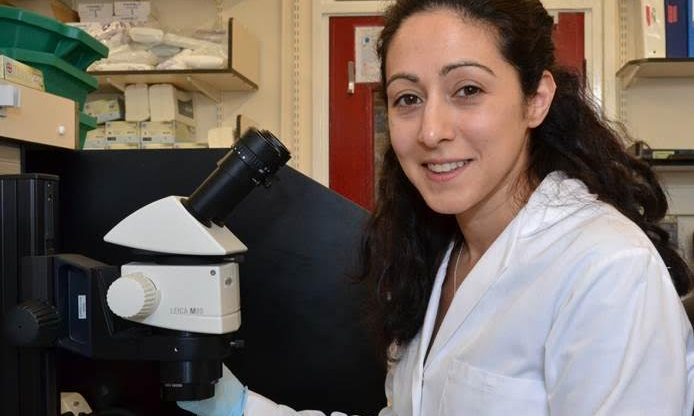 Kathy Niakan next to a microscope