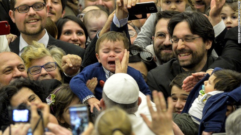 Pope Francis touches a child's face as he arrives for a meeting in the Vatican on Friday, March 6.